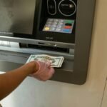 A bank customer deposits money into savings account at an ATM machine.