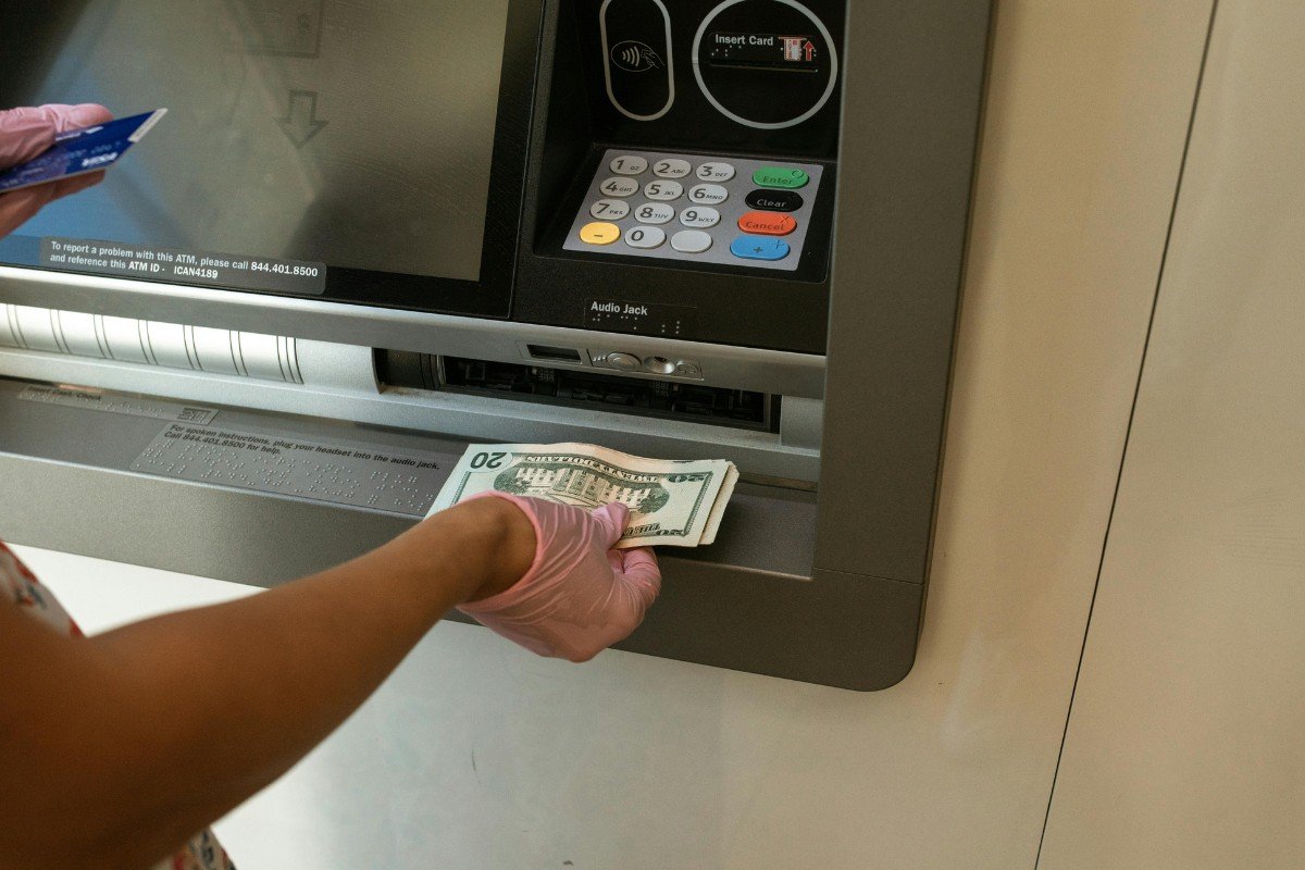 A bank customer deposits money into savings account at an ATM machine.